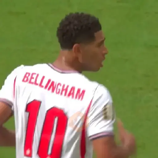 Jude Bellingham de perfil, con camiseta de Inglaterra número 10, en un partido de fútbol. Fondo verde de césped y otro jugador con camiseta roja.